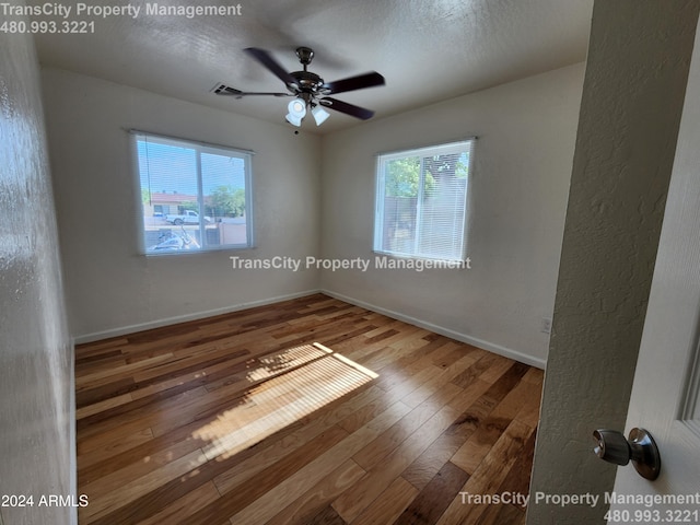 spare room with ceiling fan and wood-type flooring