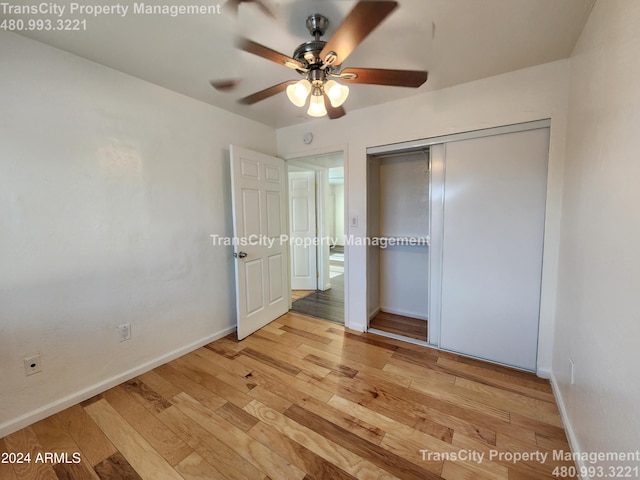 unfurnished bedroom with light hardwood / wood-style flooring, a closet, and ceiling fan