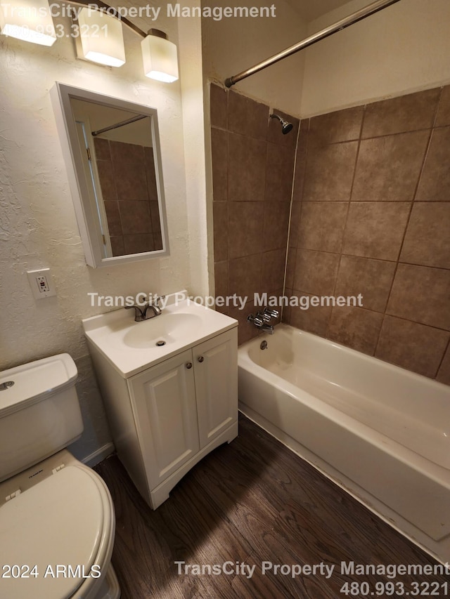 full bathroom with vanity, hardwood / wood-style flooring, toilet, and tiled shower / bath