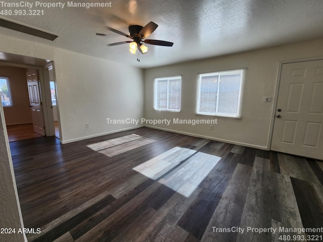 interior space featuring dark hardwood / wood-style floors, ceiling fan, and a textured ceiling