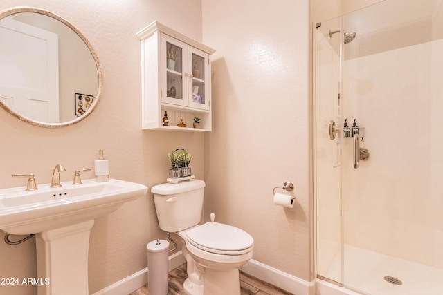 bathroom with walk in shower, sink, hardwood / wood-style floors, and toilet