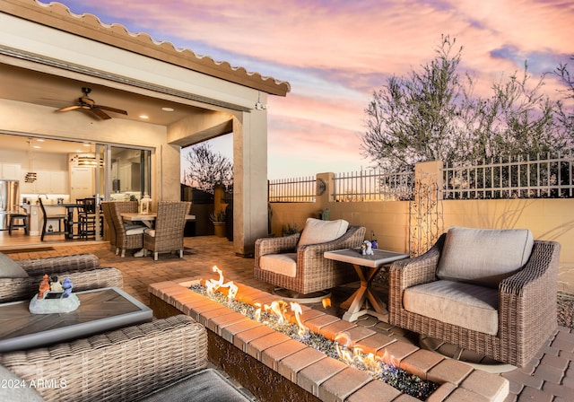 patio terrace at dusk featuring an outdoor fire pit