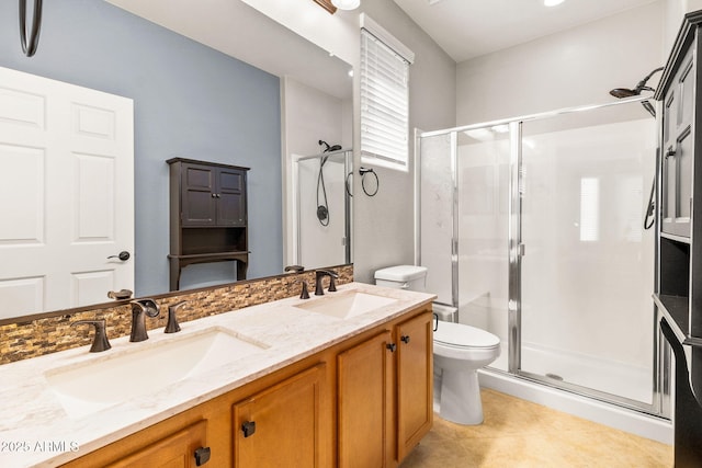 bathroom featuring tile patterned flooring, vanity, toilet, and a shower with door