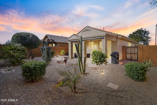 back house at dusk with a patio area