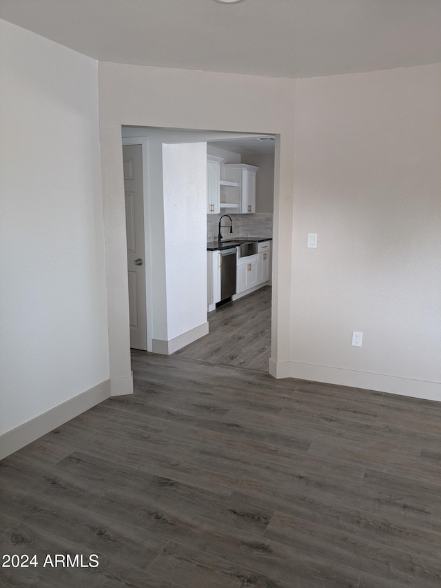 spare room featuring sink and dark wood-type flooring