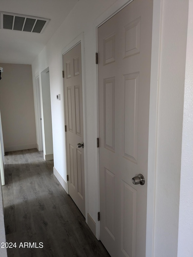 hall with dark hardwood / wood-style floors and an inviting chandelier