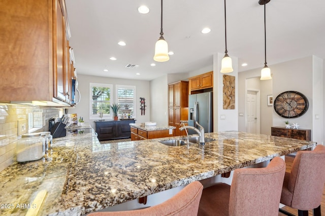 28351 N 130th Dr, Peoria, AZ 85383 - kitchen with appliances with stainless steel finishes, a sink, brown cabinetry, recessed lighting, and light stone counters