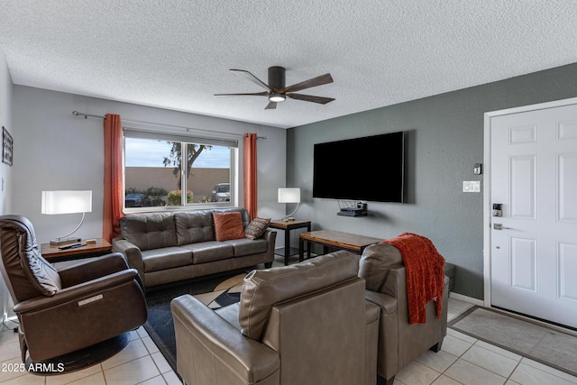 living room featuring a ceiling fan, light tile patterned flooring, and a textured ceiling