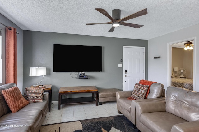 living room featuring a ceiling fan, tile patterned flooring, and a textured ceiling