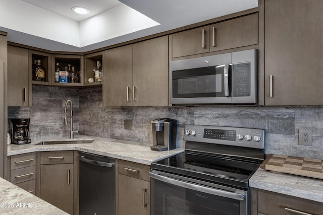 kitchen featuring appliances with stainless steel finishes, a sink, and dark brown cabinets