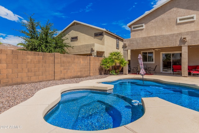 view of pool with ceiling fan, an in ground hot tub, and a patio