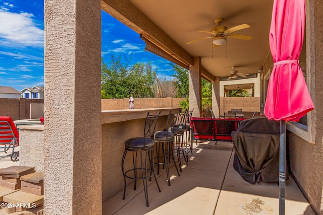 view of patio featuring exterior bar and ceiling fan