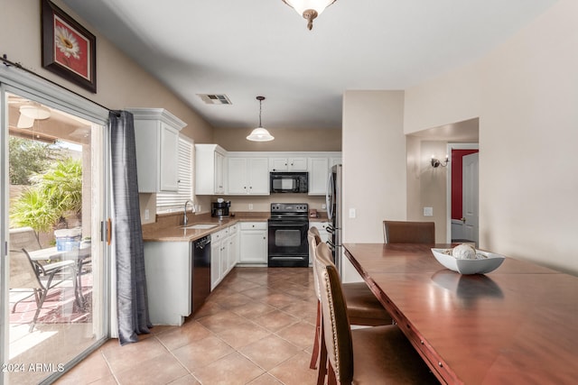 kitchen featuring black appliances, pendant lighting, white cabinetry, and light tile patterned floors