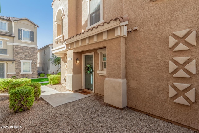 doorway to property featuring stucco siding