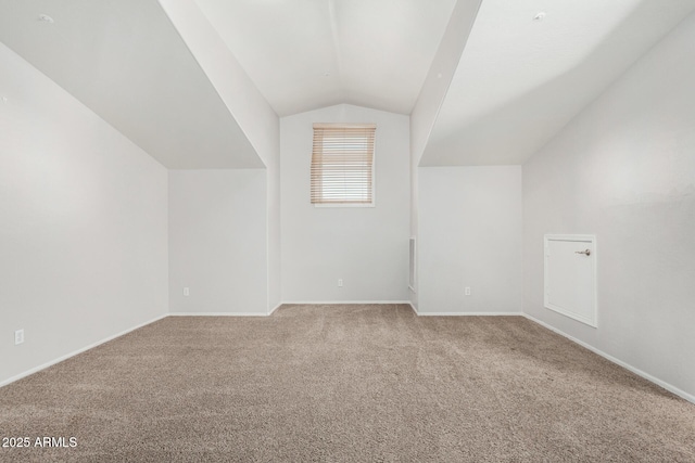 additional living space with lofted ceiling, baseboards, and carpet