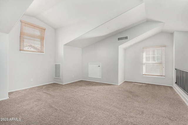 additional living space with lofted ceiling, baseboards, visible vents, and carpet flooring