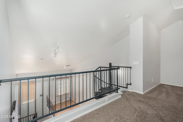 staircase featuring baseboards, vaulted ceiling, and carpet flooring