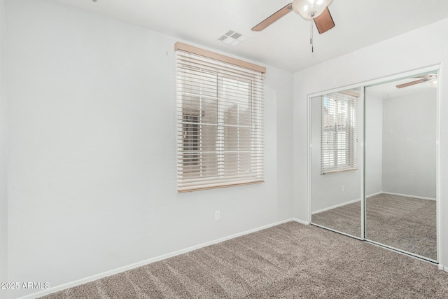 unfurnished bedroom with carpet, a closet, visible vents, ceiling fan, and baseboards