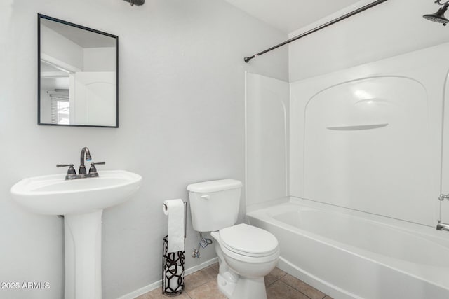 bathroom with toilet, tile patterned flooring, baseboards, and shower / bathtub combination