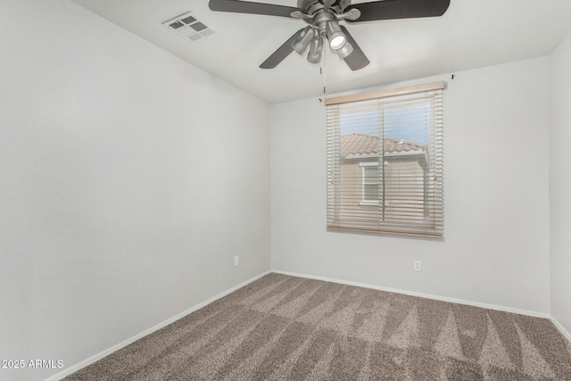 unfurnished room with carpet floors, visible vents, ceiling fan, and baseboards