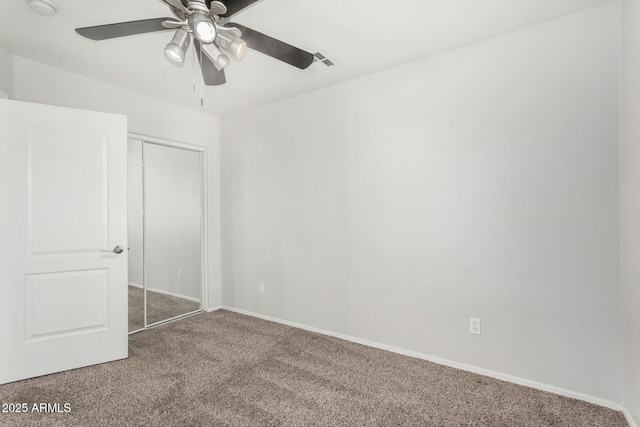 unfurnished bedroom featuring a ceiling fan, visible vents, baseboards, a closet, and carpet