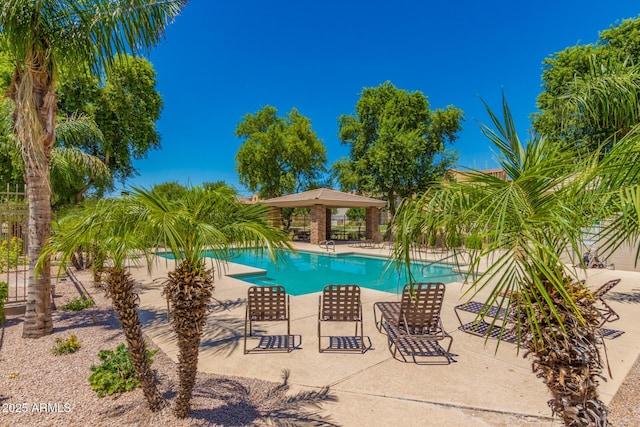 community pool with a patio and fence