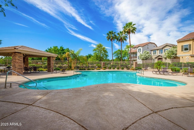 pool with a patio and fence