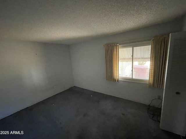8114 E Jackrabbit Rd, Scottsdale, AZ 85250 - unfurnished room with a textured ceiling and dark colored carpet