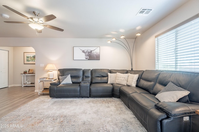 living area with baseboards, ceiling fan, visible vents, and wood finished floors