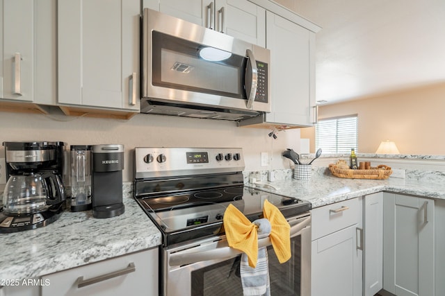 kitchen featuring appliances with stainless steel finishes and light stone counters