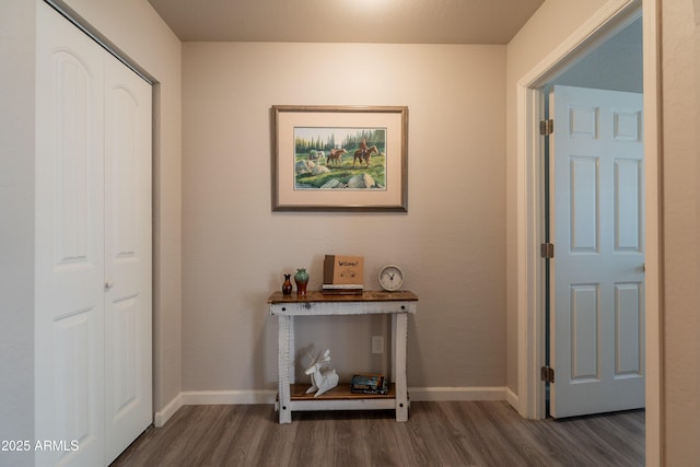 hallway featuring baseboards and dark wood-type flooring