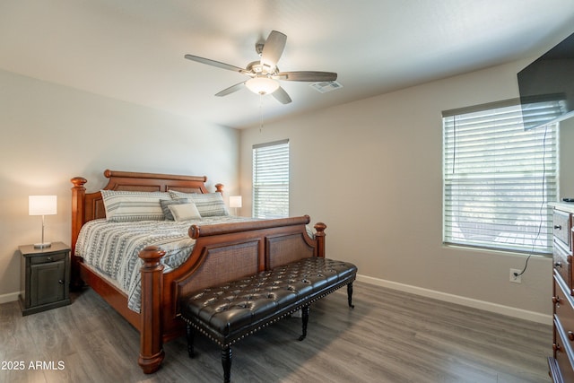 bedroom with a ceiling fan, baseboards, visible vents, and wood finished floors