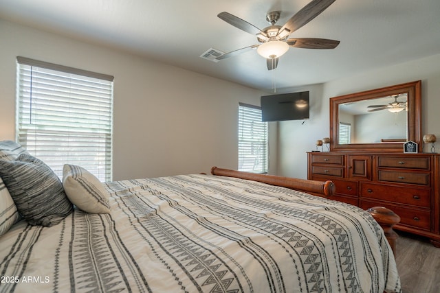bedroom featuring visible vents, a ceiling fan, and wood finished floors