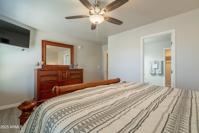 bedroom with a ceiling fan, baseboards, and wood finished floors