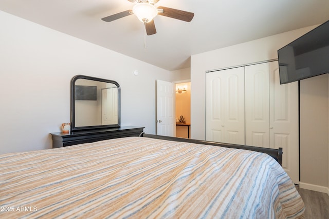 bedroom with baseboards, ceiling fan, wood finished floors, and a closet