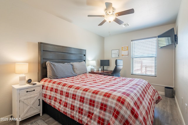 bedroom featuring ceiling fan, baseboards, visible vents, and wood finished floors