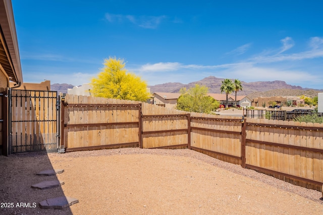 view of yard featuring fence, a mountain view, and a gate