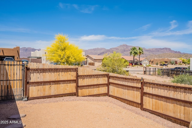 view of yard with a gate, a residential view, a mountain view, and fence private yard