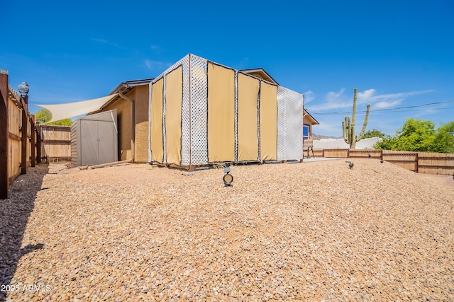 exterior space featuring an outbuilding, a shed, and a fenced backyard