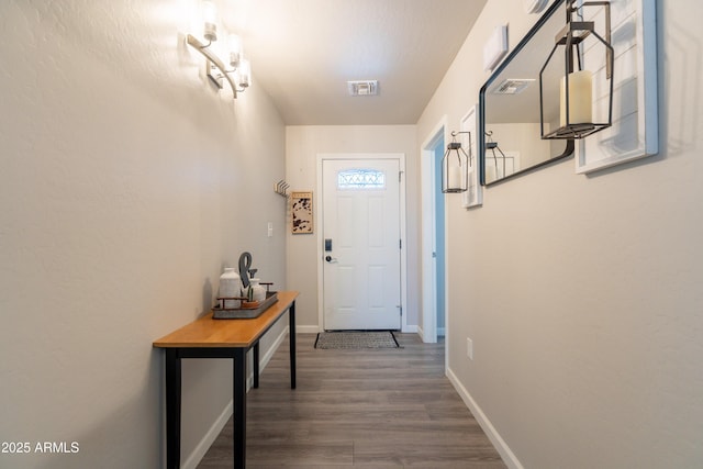 entryway with baseboards, visible vents, and wood finished floors