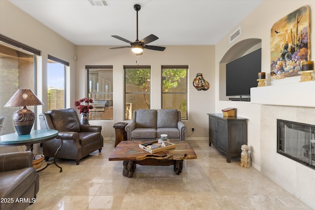 living room with a fireplace and ceiling fan