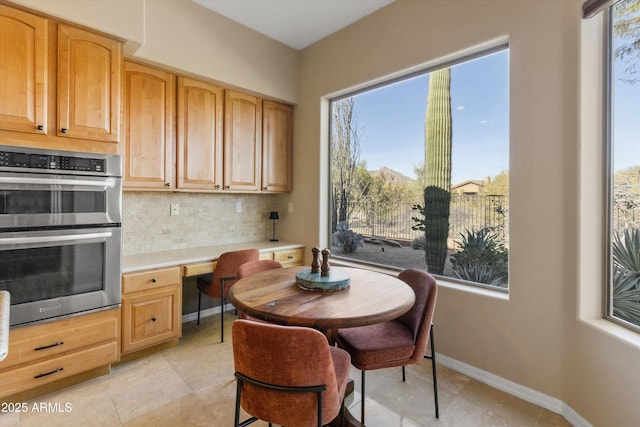 dining space featuring light tile patterned floors and built in desk