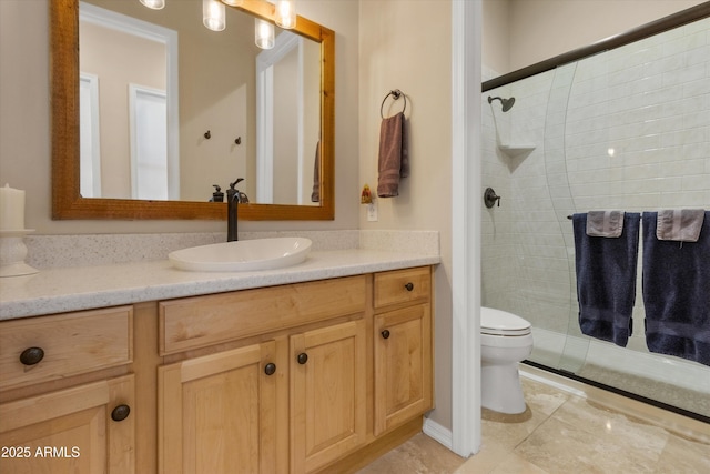 bathroom featuring tile patterned flooring, a shower with door, vanity, and toilet