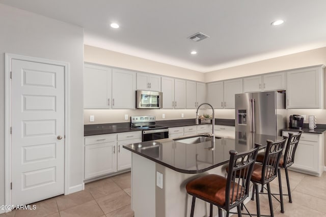 1370 W Siboney St, San Tan Valley, AZ 85143 - kitchen with a breakfast bar, appliances with stainless steel finishes, dark countertops, a sink, and visible vents