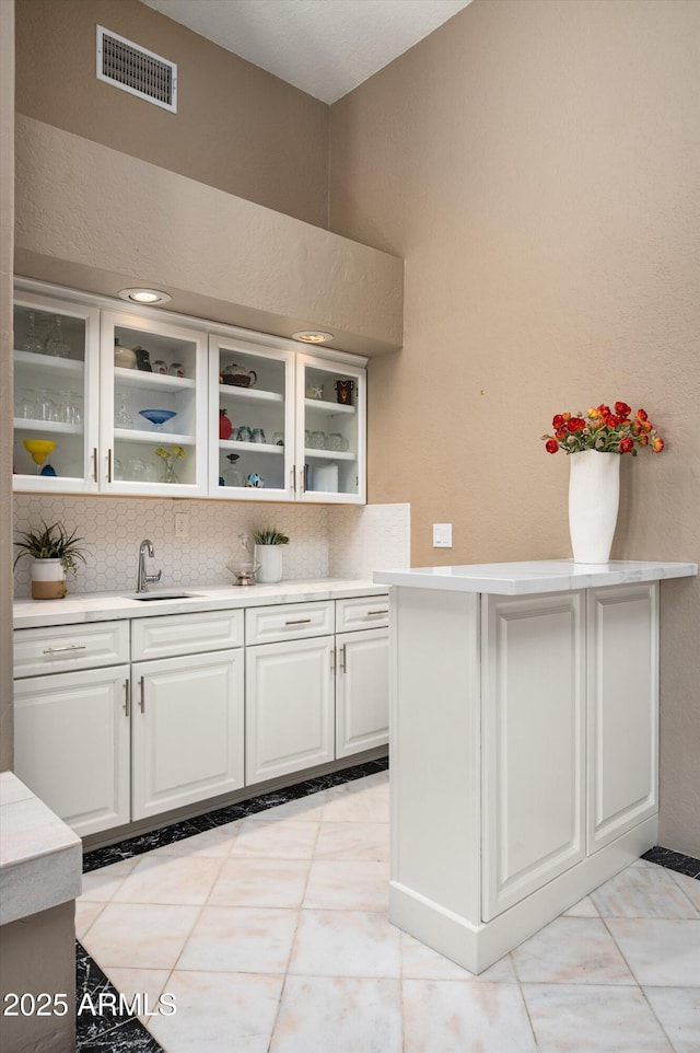 8601 E De La O Rd, Scottsdale, AZ 85255 - kitchen featuring a sink, glass insert cabinets, decorative backsplash, and light countertops