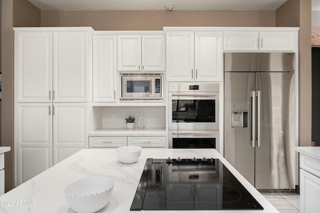 8601 E De La O Rd, Scottsdale, AZ 85255 - kitchen featuring stainless steel appliances, white cabinetry, tasteful backsplash, and light stone countertops