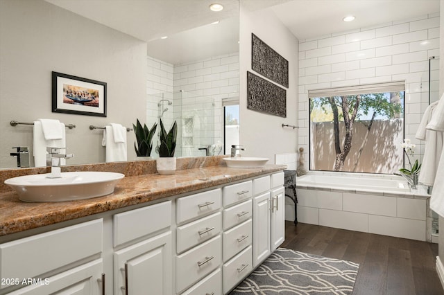 8601 E De La O Rd, Scottsdale, AZ 85255 - bathroom with wood finished floors, double vanity, tiled shower, a bath, and recessed lighting