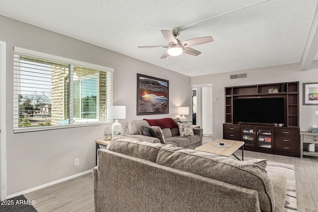 living room featuring hardwood / wood-style floors, a textured ceiling, and ceiling fan