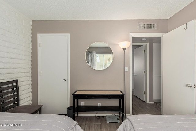 bedroom featuring dark hardwood / wood-style flooring and a textured ceiling