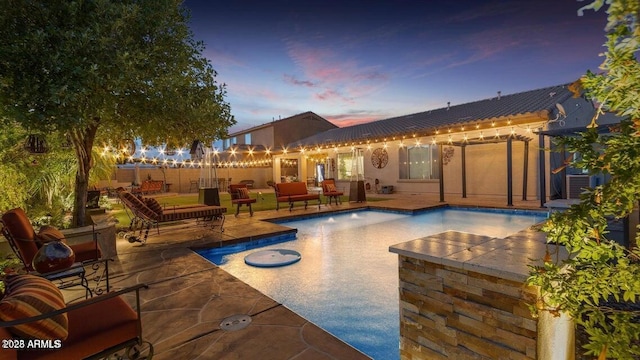 pool at dusk with an outdoor hangout area, a patio area, and central air condition unit